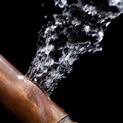 A bursting copper pipe in Estevan, with water gushing out.