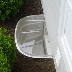A vinyl basement window and covered window well in Carnduff