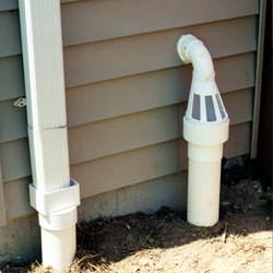 A grated sump pump discharge line fitting in Oxbow